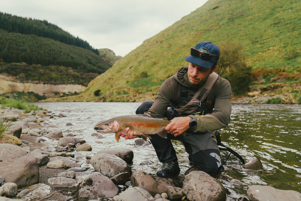 George with one of his sizeable trouts, wearing the Brownie Fish Face Hoodie, the Drift Wader and Drift Boots.