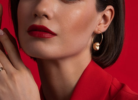 NJO Designs gold plated puffy heart hoop on model wearing red