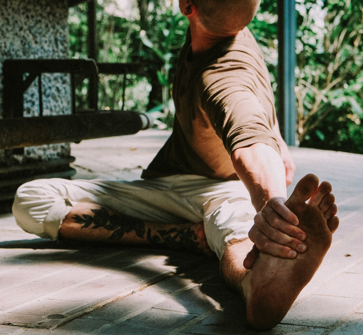 Man stretching in bare dirty feet