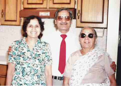 A mother, her son, and his wife standing in their kitchen smiling, show the fun in candid photos.