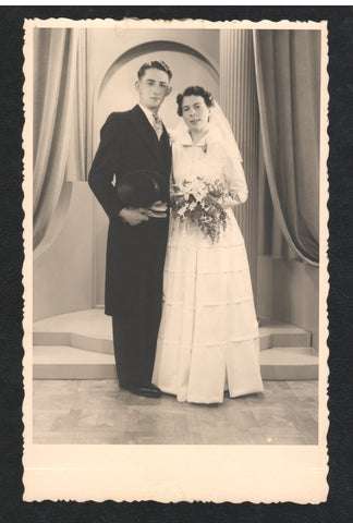 A high-quality print of the formal wedding portrait of a European couple. The groom wears a black suit and the bride radiates beauty in a white gown.