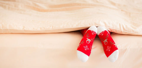 Children's feet in winter socks in bed