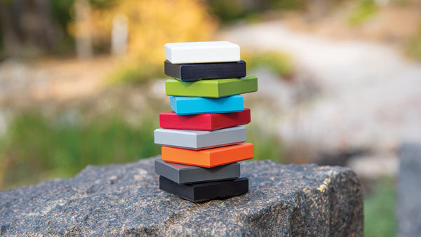 Image: All colors of Loll's HDPE sample blocks stacked on a rock.