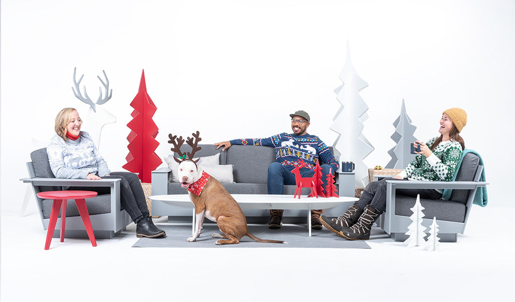 Loll team members sitting on Loll furniture dressed for the winter holidays. 