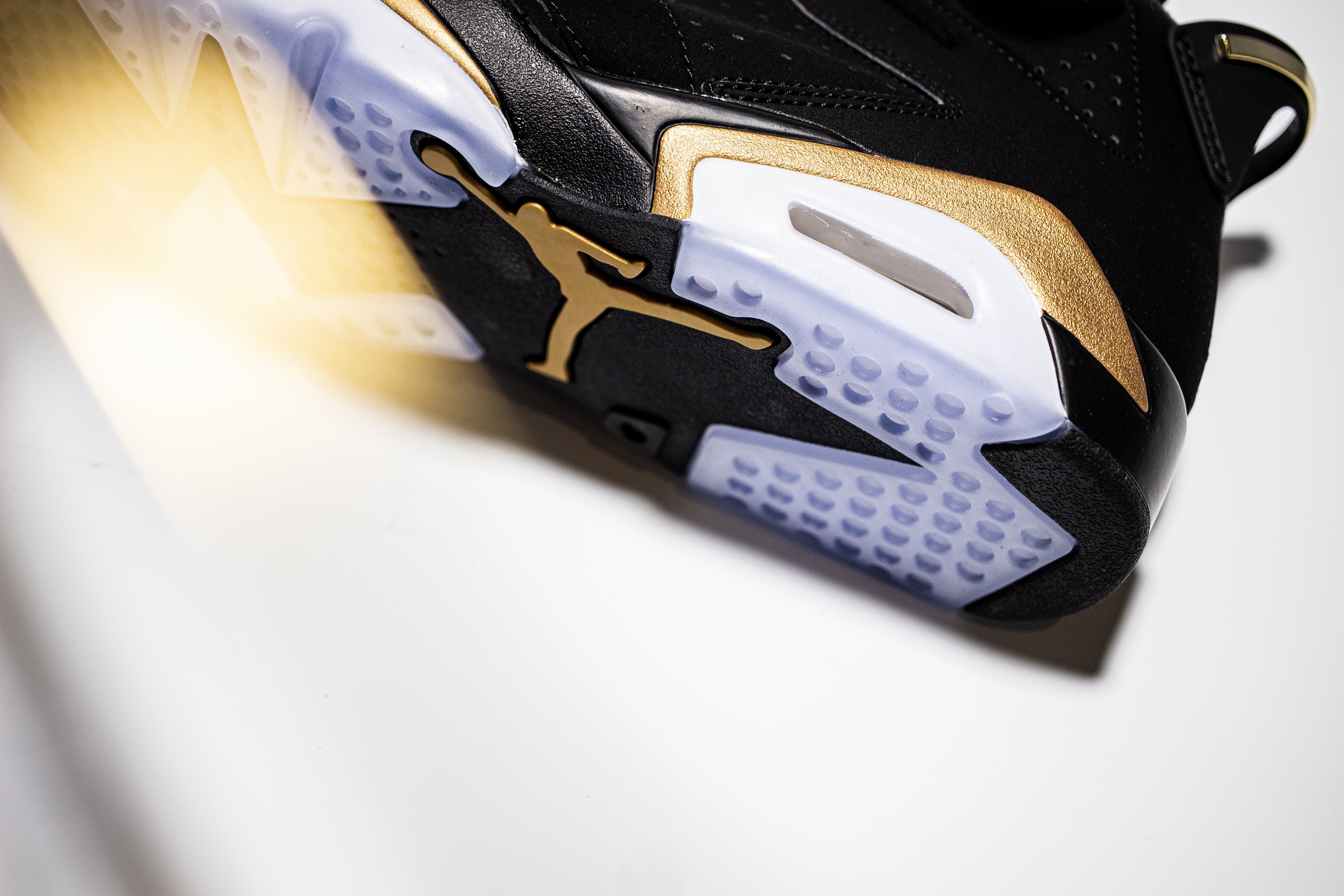 Midsole angle view of Jordan 6 black gold sneaker highlighting the logo