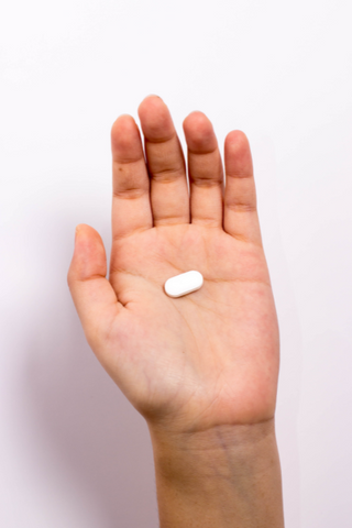 A person holding a single choline supplement in the form of alpha-gpc