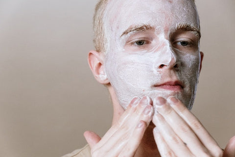 A man using a CBD acne face wash as part of his regular skin care regimen.