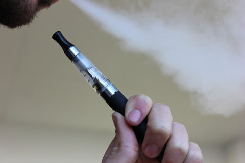 A person using a Delta-8-THC vaporizer, known for fast acting, short-lived psychoactive effects. 