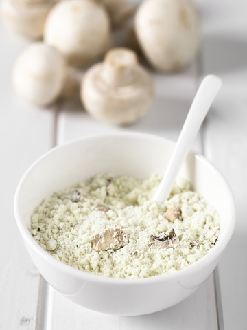 A bowl of whole powdered mushroom, which is dense and flavorful for cooking or supplementation