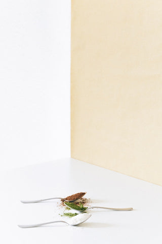 Three spoons arranges on a table, each filled with various types of kratom powder