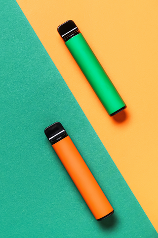A green Delta-11 vape and an orange Delta-11 vape laid on a geometric background to show an example of inhalation-style dosing methods.