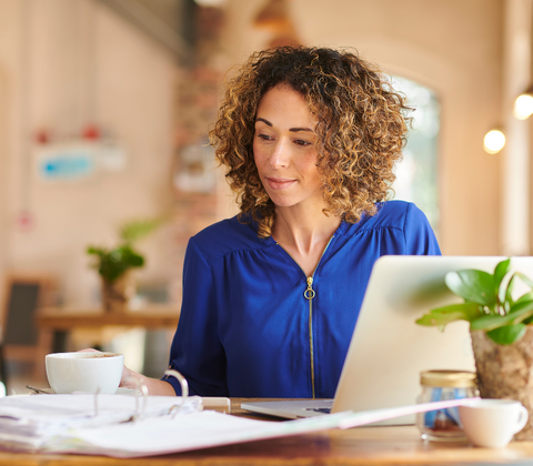 A woman sitting at her desk to focus on work after taking L-theanine capsules