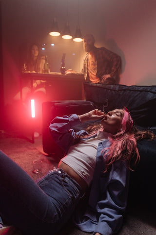 A relaxed woman deep in thought while smoking a cannabis joint.