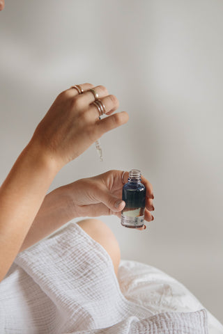 A woman measuring out a portion of CBD oil from a glass tincture bottle