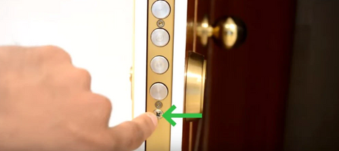 Mano de cerrajero señalando las partes de una puerta