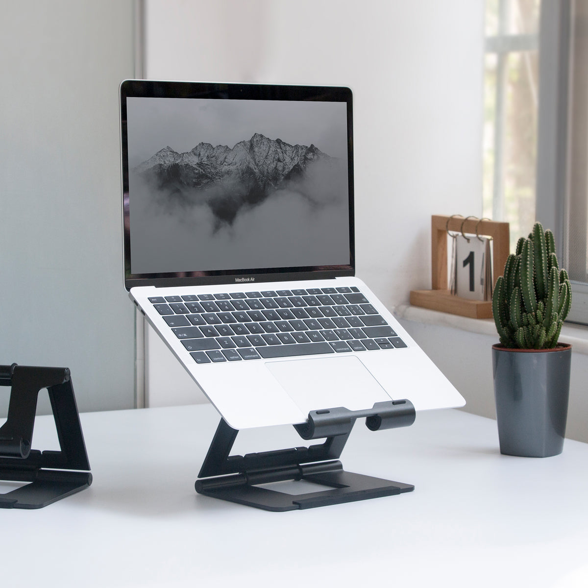 Black Macbook Air stand on desk, laptop riser for office, study