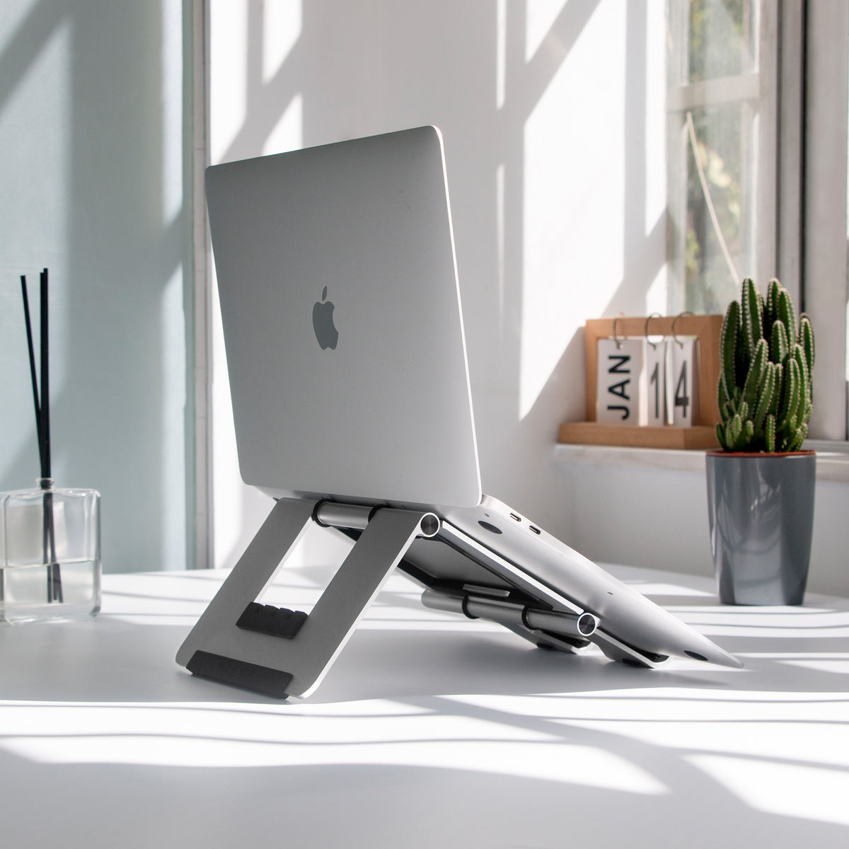 RMOUR foldable laptop riser with Macbook Air on desk in sunny day, study near window, jan 14