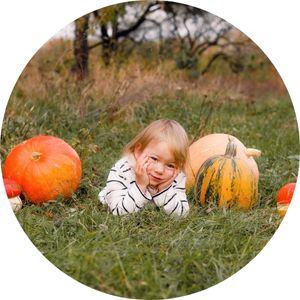 Small Child Next to Pumpkins