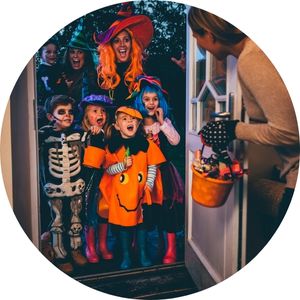 Woman Handing Out Candy to Halloween Trick or Treaters