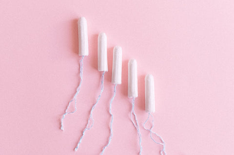 opened tampons on pink background