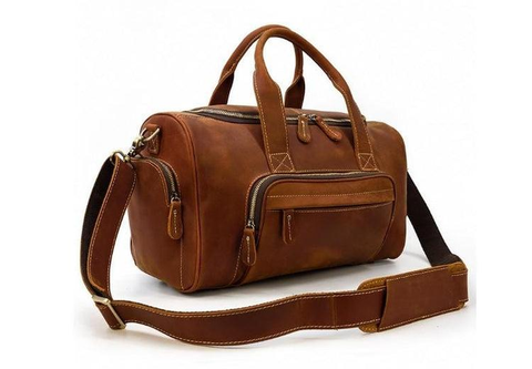 A fancy brown leather duffel bag with a swag
