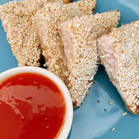 Gluten free sesame prawn toast set on a blue plate with a gluten free sweet chilli dip