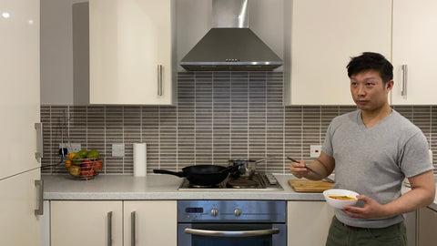 Vincent holding a Chinese bowl and chopstick in the home kitchen