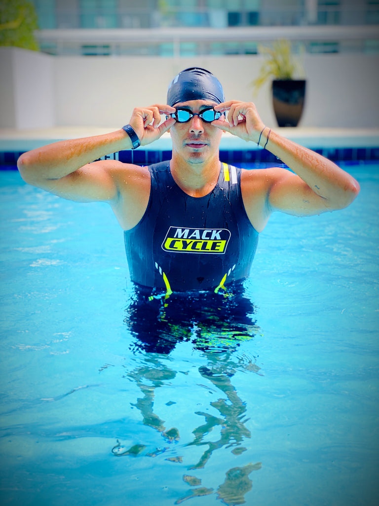 Manuel Novoa wearing mack cycle swim skin emerges from a pool holding onto his goggles