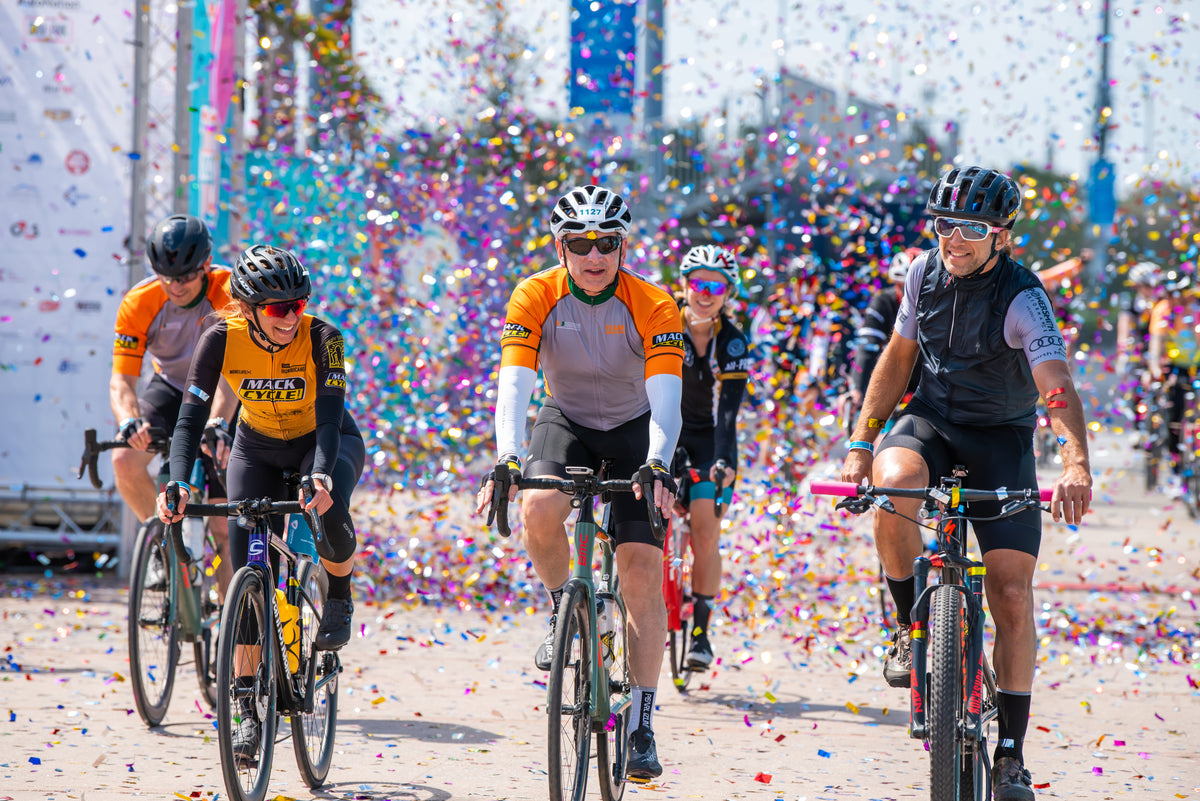 Rachel, dr. nimber, and Randy Egues finishing the dolphins challenge cancer 100 mile bike ride under a rain of confetti