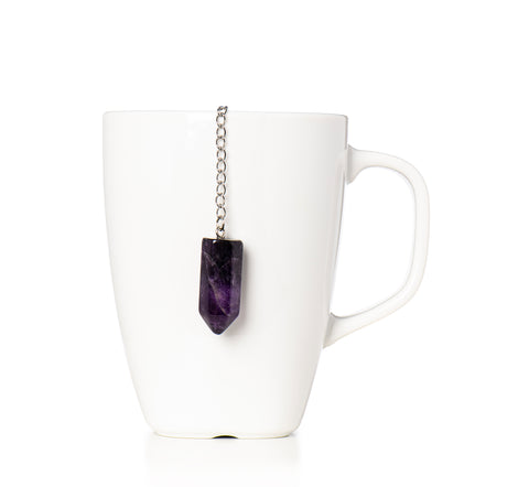 purple amethyst crystal on a chain attached to a tea infuser