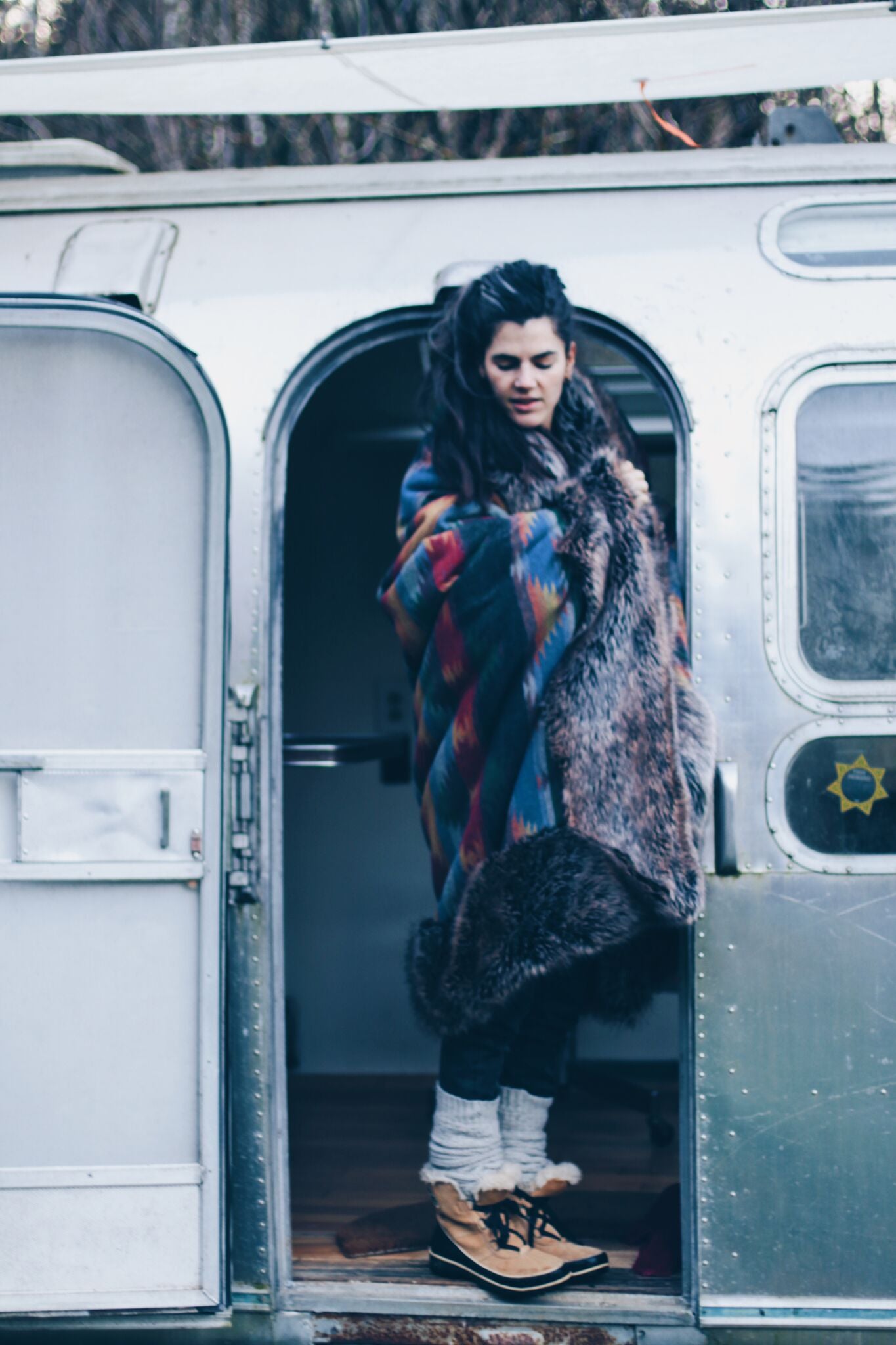 woman standing in doorway wrapped in faux fur throw