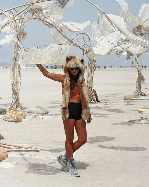 woman wearing orange top, black shorts, sneakers, and faux fur hood