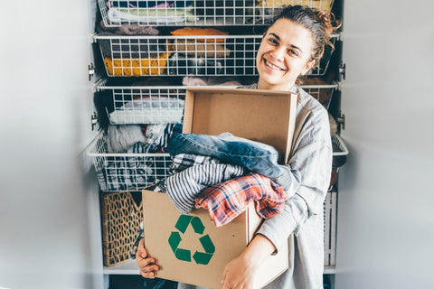 person decluttering and packing stuff to recycle