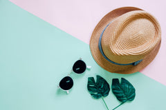 sunglasses and hat with leaves and pink and green background