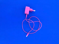 pink charging chord unplugged on blue background