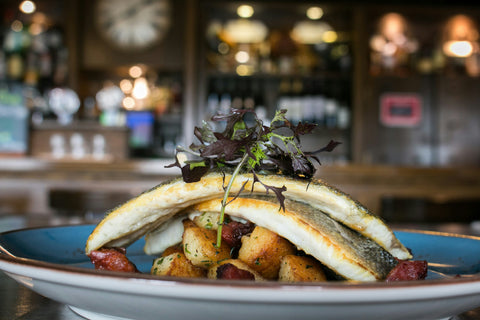 Pan-Fried Sea Bass on a Bed of Golden Potatoes with Chorizo and Herbs