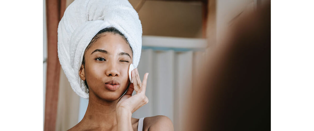 woman cleaning face with towel on head