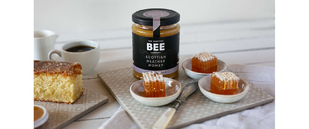 heather honey in a jar, heather honeycomb in small plates and a honey cake