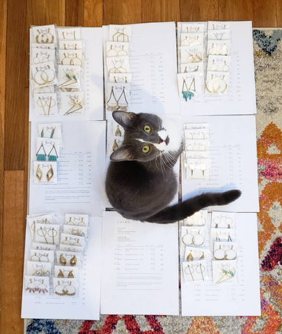 Cat lounging on floor with jewelry displayed