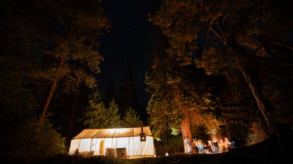 The glow of the guide/kitchen wall tent next to the Grande Ronde River and amongst the stars.