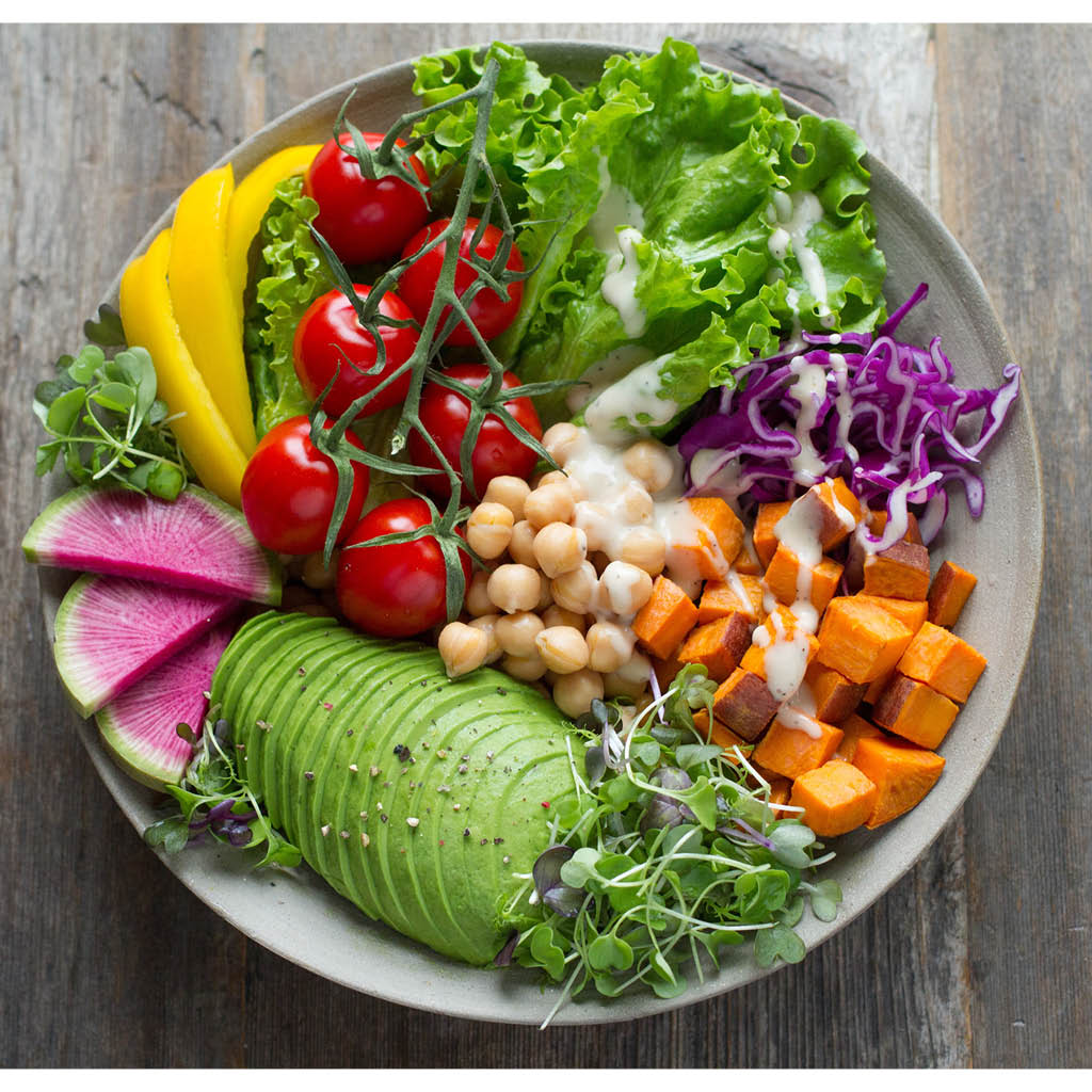 Ruokalautanen täynnä terveellisiä syötäviä, avocadoa, tomaatteja, salaattia, kikherneitä