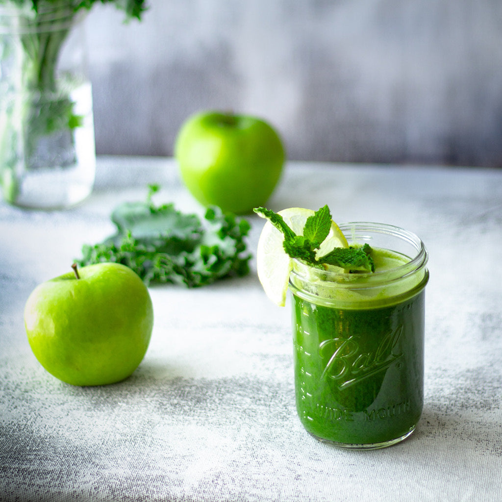 Vihreä terveysjuoma ja omenat asetelma