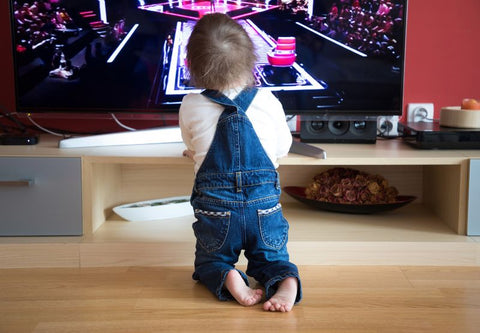 Un tout petit à genoux devant la télévision