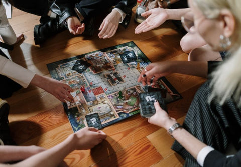 Des amis jouent sur un jeu de plateau sur une table en bois