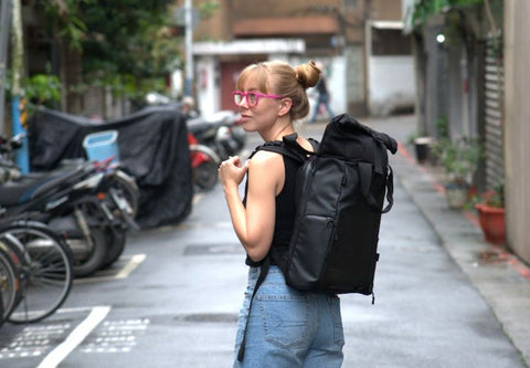 girl wearing pink gaming glasses and carrying backpack on street