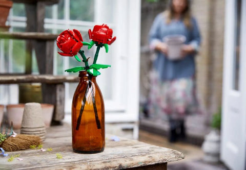 Deux roses lego dans un vase sur une table