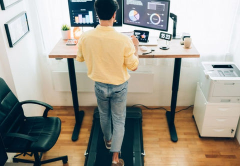 Ein Mann sitzt an einem Schreibtisch und steht vor Computern
