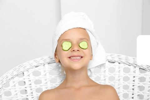 kid in a spa with cucumber slices over eyes