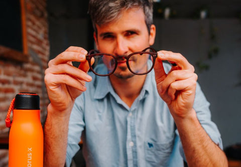 Junger Mann hält eine Anti-Blaulicht-Brille in den Händen