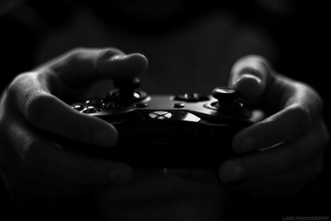 manette gaming en noir et blanc tenus par des mains